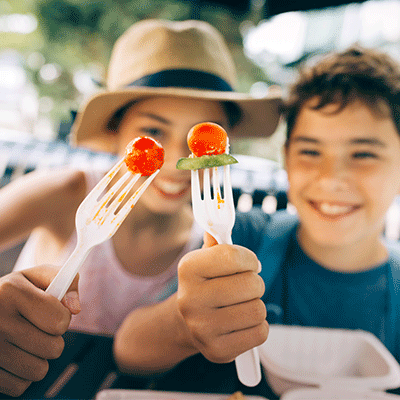 kids smiling eating tomato