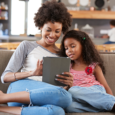 mom and daughter on couch on ipad