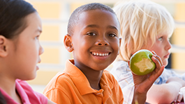 Boy smiling with green apple in his hand