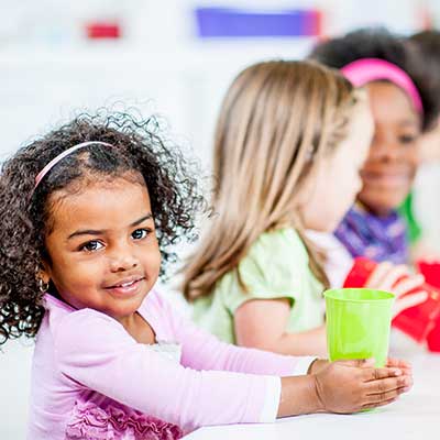 Girl drinking out of green cup at lunch