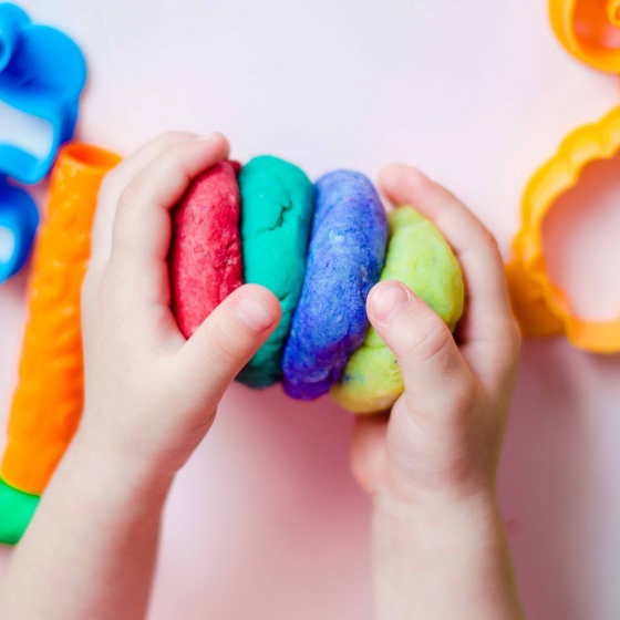 a child's hands playing playdough